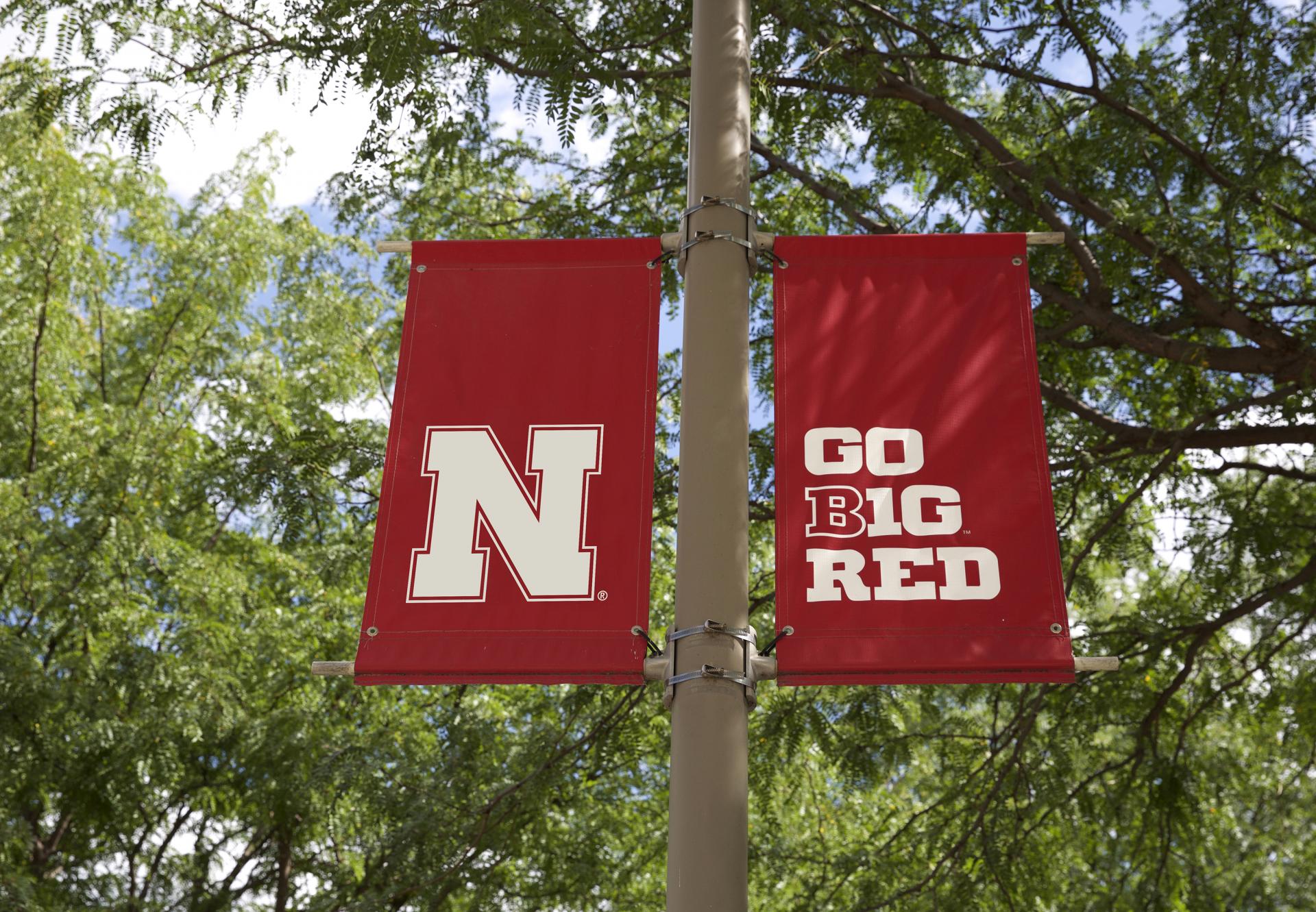 light pole with red banner with the Nebraska N and Big 10 logo