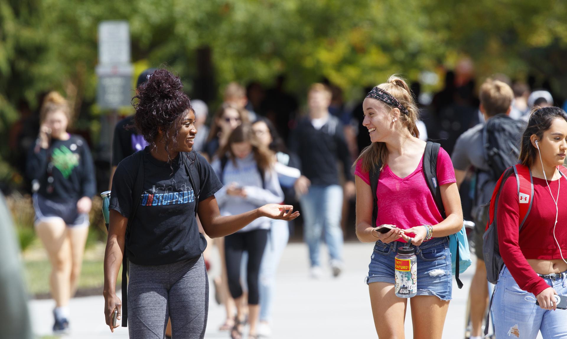 Students walking together on busy campus sidewalk