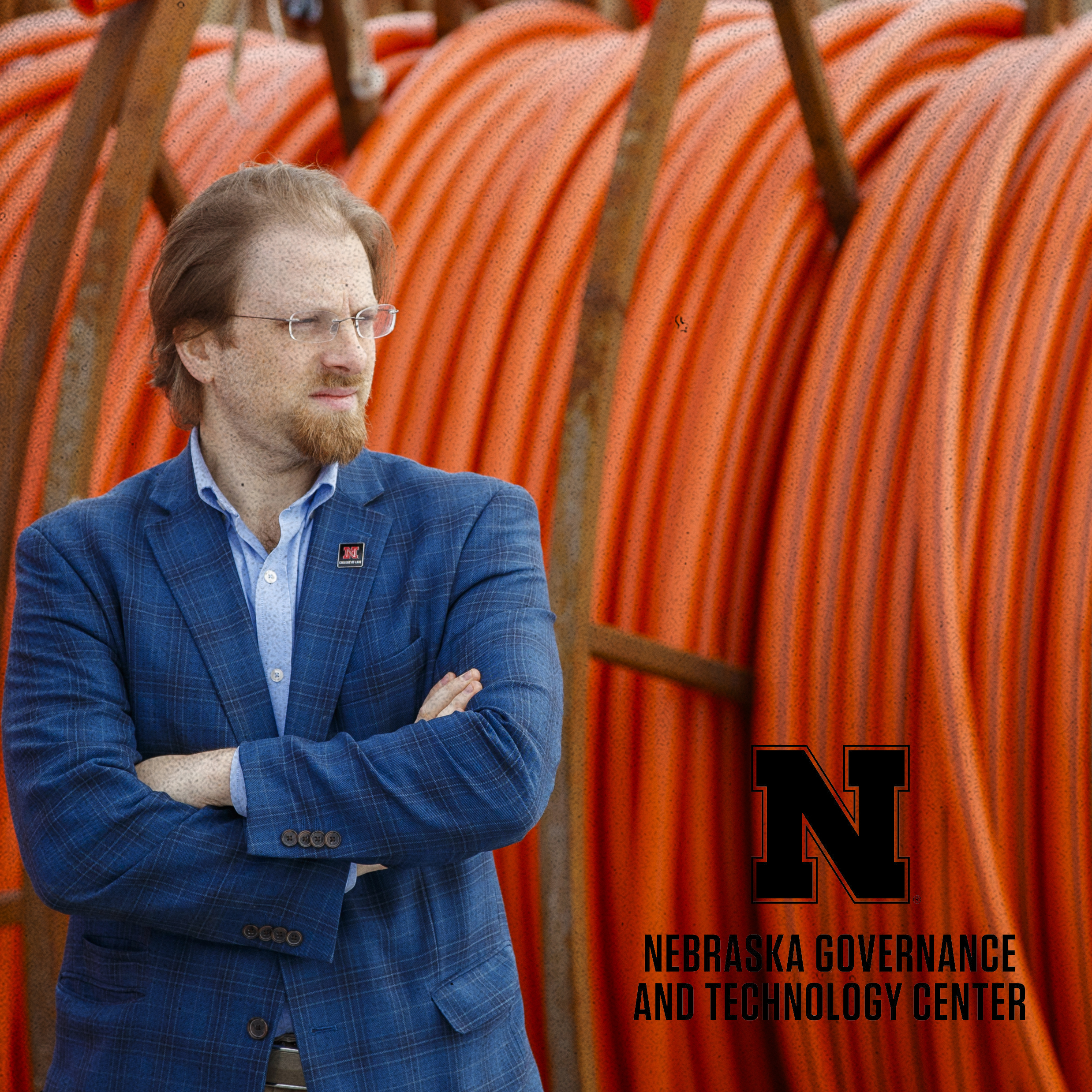 Portrait of Law Professor Gus Hurwitz in front of a large bundle of orange cables.